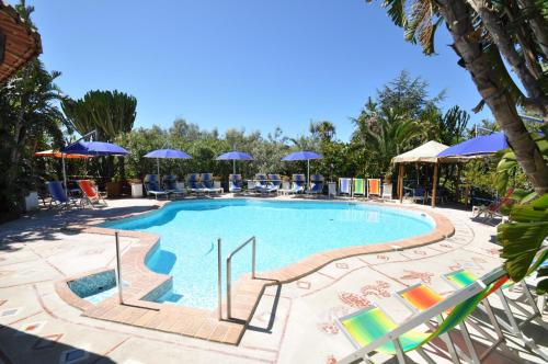 阿纳卡普里伊娃别墅酒店的度假村的游泳池配有椅子和遮阳伞