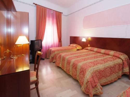 雷卡纳蒂Hotel Ristorante La Ginestra的酒店客房设有两张床和电视。