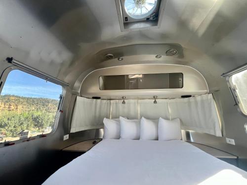 奥德维尔Airstream Canyon的窗户客房内的一张白色床