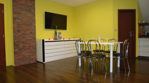 KaniankaPenzión Melódia的用餐室设有黄色的墙壁和桌椅