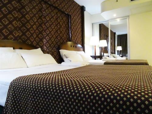 布宜诺斯艾利斯阿巴斯托酒店的酒店客房,设有两张床和镜子