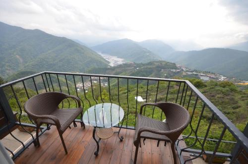 仁爱乡清境观湖四季民宿的山景阳台上配有两把椅子和一张桌子