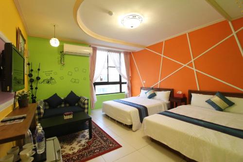 恒春古城垦丁迪亚克旅店的酒店客房,设有两张床和一张沙发