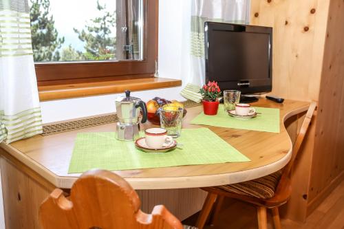 新波南特Alps Residence的一张带两个杯子的小木桌和一台电视