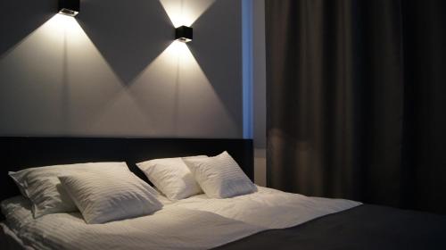 什切青Art Apartment Szczecin的一间卧室配有带2个枕头和2盏灯的床