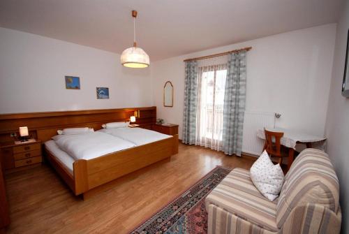 圣坎迪朵Appartments Oberhofer的一间卧室配有一张大床和一张沙发