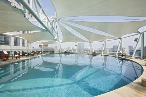 佛山佛山恒安瑞士大酒店的一座大楼顶部的游泳池,配有遮阳伞