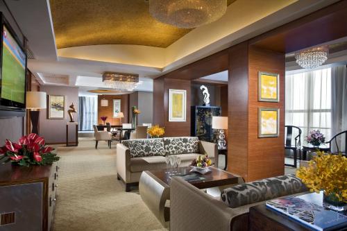 佛山佛山恒安瑞士大酒店的客厅配有沙发和桌子