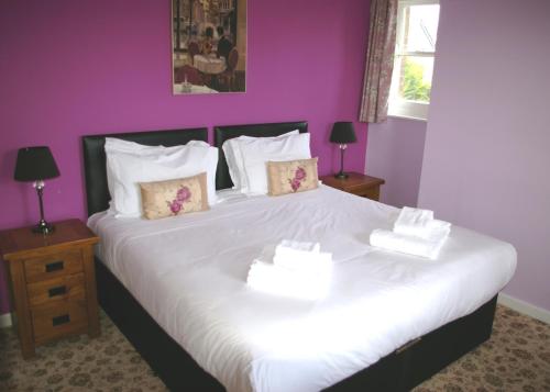 Broadmayne黑狗酒店的卧室配有一张白色大床和紫色墙壁