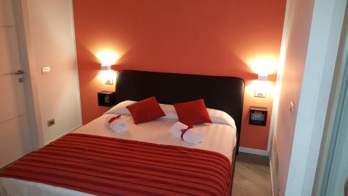 菲乌米奇诺拉里拉住宿加早餐旅馆的一间卧室配有一张带两个红色枕头的床