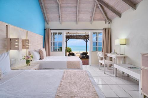 Five Islands VillageHawksbill Resort Antigua - All Inclusive的一间卧室配有两张床和一张桌子