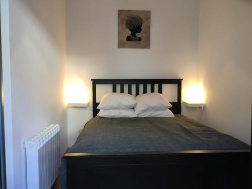 巴里吉斯Appartement n° 32的一间卧室配有带2个枕头和2盏灯的床