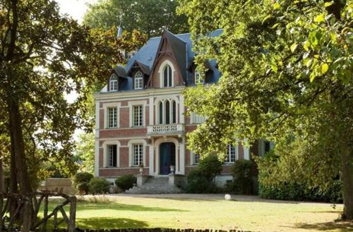 ContresMaison d'hôtes Le Manoir de Contres的黑色屋顶的大型白色房屋