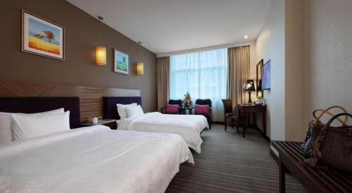 ShenzhenShenzhen Hanyong Hotel Fuyong Branch的酒店客房配有两张床和一张书桌