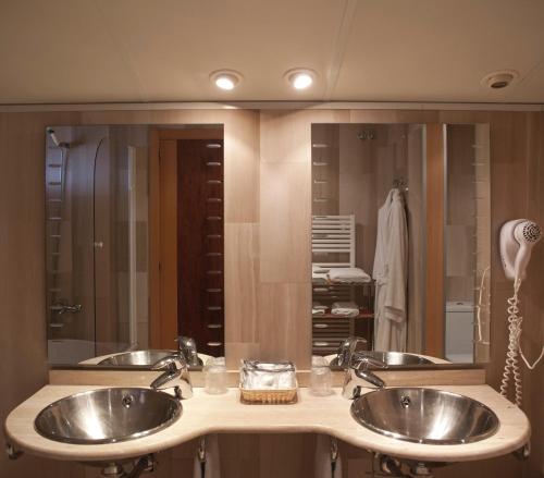 BotHotel & Spa Can Josep的一间带两个盥洗盆和大镜子的浴室