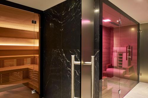 圣莫里茨水晶酒店的一间带步入式淋浴间和玻璃门的浴室