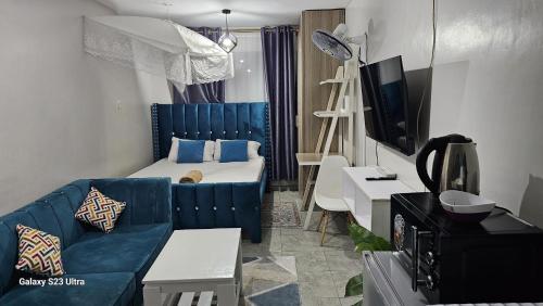 内罗毕Pazoori Furnished Studio and 1 bedroom的客厅配有蓝色的沙发和电视