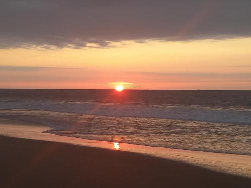 洛斯拉甘斯Casa Entre Rocas y Veleros的日落在海滩上与大海