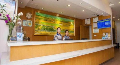 郑州7 Days Inn Zhengzhou Hongzhuan Road Provincial Hospital Metro Station的两人站在餐厅柜台