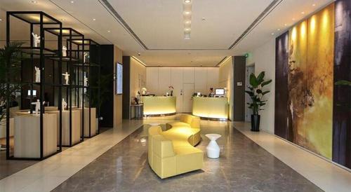 上海Jinjiang Metropolo Shanghai Xujiahui Nanhuating Hotel的客厅配有黄色的沙发和桌子