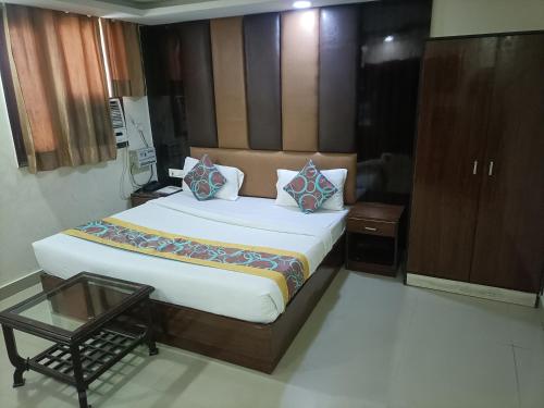 新德里Hotel Green tark Near IGI Airport Delhi的一间卧室配有一张大床和一张桌子