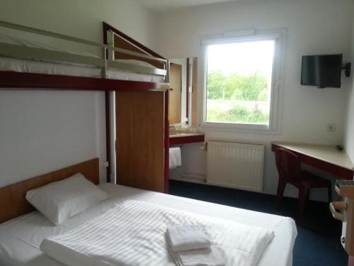 不莱梅不来梅24小时汽车旅馆的一间卧室配有一张床、一张书桌和一个窗户。