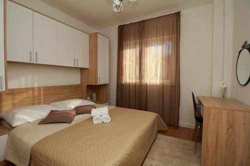 马卡尔斯卡Apartments Obitelj Vuletić的一间卧室配有一张床、一张书桌和一张书桌