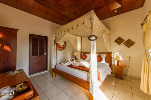 甘地达萨卡迪达莎罗摩辛塔酒店的一间卧室配有一张带天蓬的床