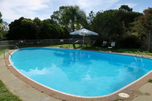 林道林德山酒店的一个带遮阳伞的大型蓝色游泳池