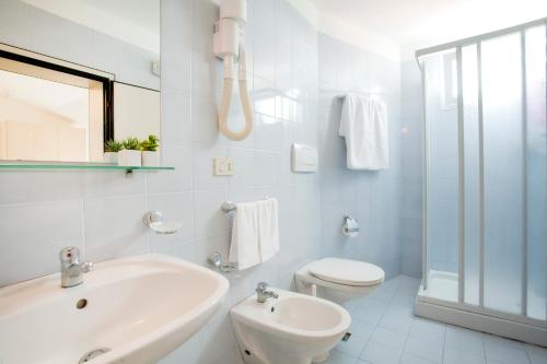 里乔内Hotel Universal的白色的浴室设有水槽和卫生间。