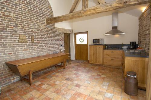 马塞克Vakantiewoning Venderhof的厨房设有砖墙木凳