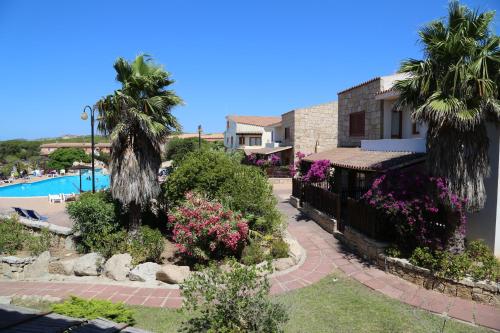 帕劳克拉布艾斯公寓式酒店的一座带游泳池、棕榈树和鲜花的度假村