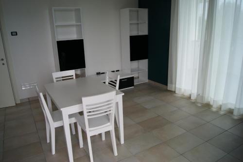 卡萨诺韦马尔彭萨莱西登斯公寓式酒店的一间带桌子和白色椅子的用餐室