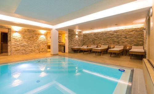 格拉茨Hotel Süd Graz的一座配有桌椅的酒店游泳池