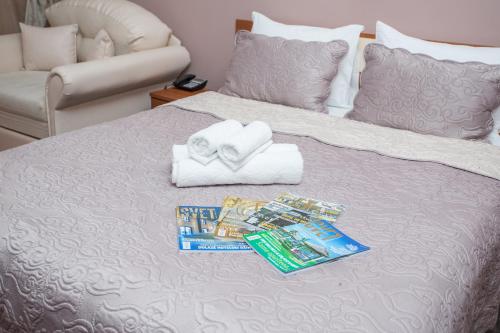 皮罗特Sin-Kom Hotel Garni的一张带两条毛巾和一堆牙膏的床