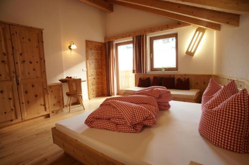 皮茨河谷阿兹尔恩瑟亚霍夫儿童农场旅馆的客房配有红色和白色枕头。