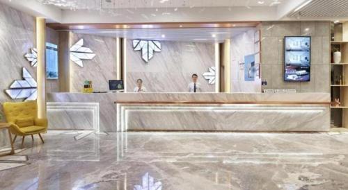 深圳GreenTree Eastern Hotel Shenzhen Nanshan District Qianhai Free Trade Zone Lilin Metro Station的大堂设有前台和黄色椅子