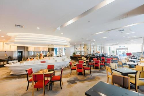 深圳Grand Soluxe Zhongyou Hotel Shenzhen的一间带桌椅的餐厅和一间酒吧