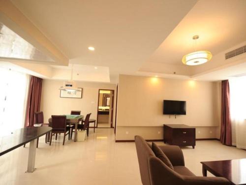 苏州GreenTree Inn Jiangsu Suzhou New District Science and Technology College Business Hotel的一间带桌子的客厅和一间餐厅