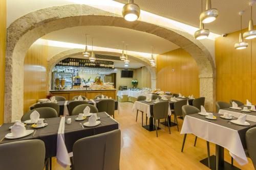 里斯本里斯本BE酒店的一间带桌椅的餐厅和一间酒吧