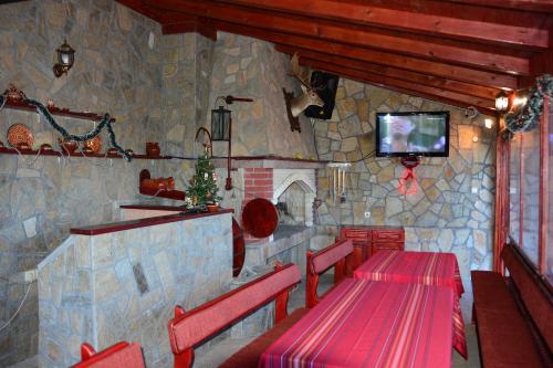 Lyaskovo戴安娜家庭旅馆的一间设有两张桌子和一台电视的石墙餐厅