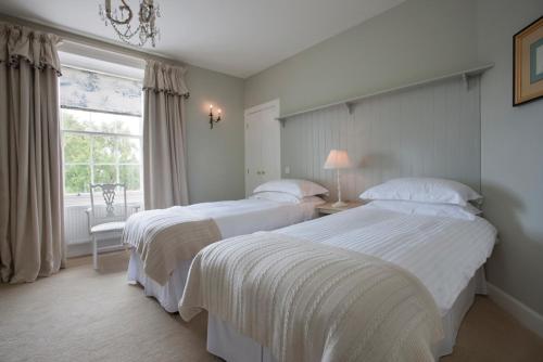 Ratho布里奇宾馆的一间卧室设有两张床和窗户。
