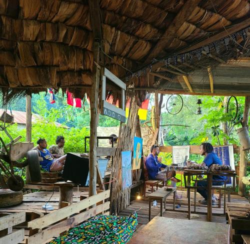 阿鲁沙Aroma Home - Eco-Cabins on a Coffee Farm的一群坐在餐厅桌子上的人