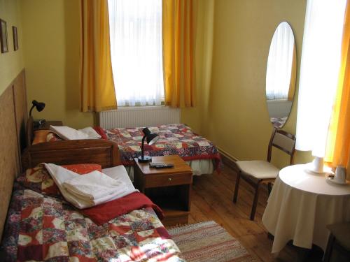 塔尔图卡斯塔尼住家酒店的酒店客房设有两张床和一张桌子。