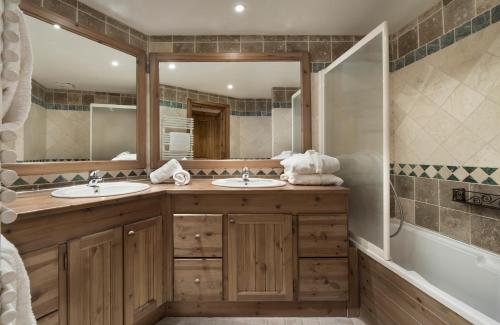 葱仁谷Ancolies Val Thorens的一间带两个盥洗盆和大镜子的浴室