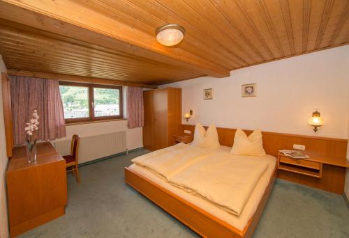 滨湖采尔克里斯托尔公寓酒店的一间卧室设有一张带木制天花板的大床