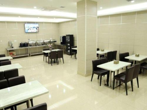 常州GreenTree Inn Jiangsu Changzhou Henglin Town Shuntong Road Express Hotel的一间带桌椅的用餐室和一间厨房