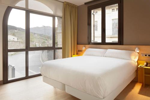 SeguraHotel Imaz的一间卧室设有一张大床和一个大窗户