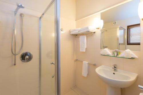 陶波绿洲海滩度假酒店的带淋浴和盥洗盆的浴室