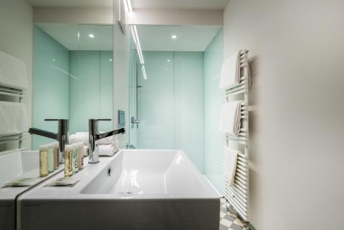 卢塞恩市中心狮子纪念碑附近顶层公寓的浴室设有白色水槽和镜子